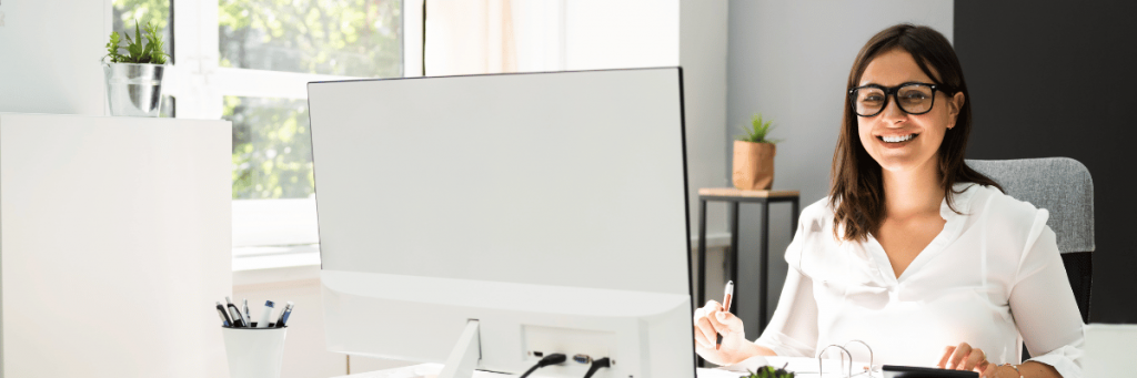 Mulher branca observando um computador.